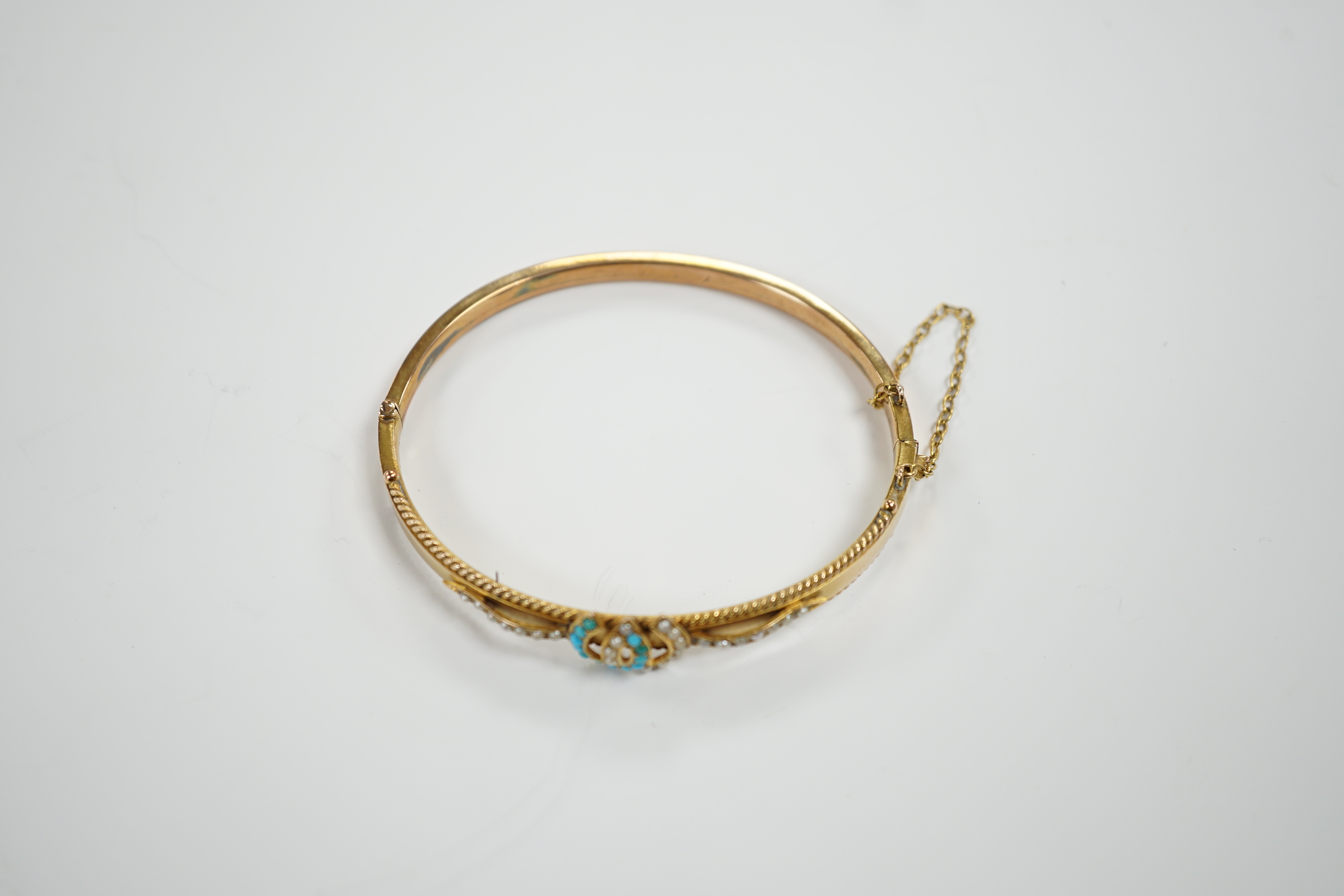 A 9ct gold, seed pearl and turquoise set twin horseshoe motif hinged bangle, gross weight 7.5 grams.
